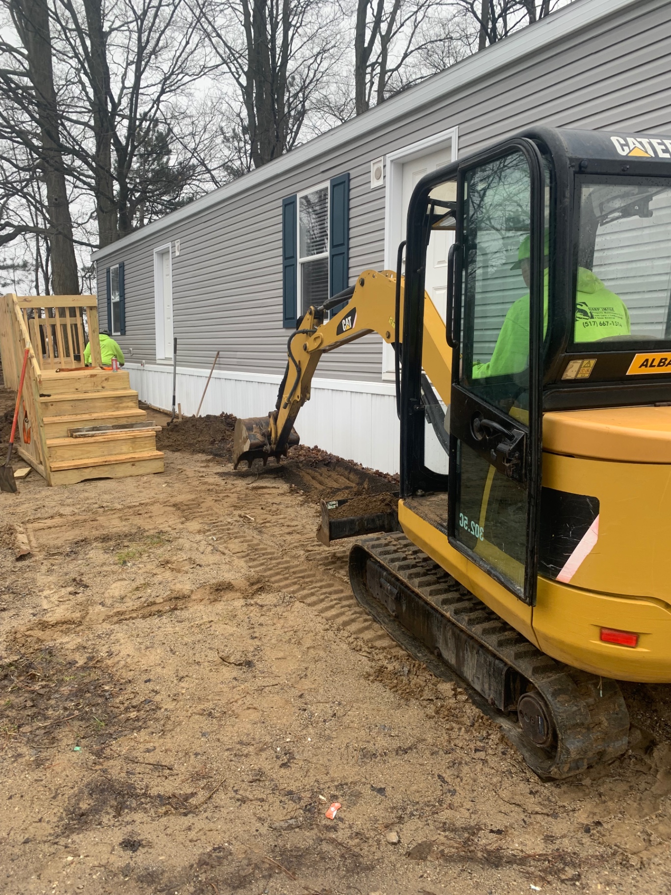 Sharp Image crew running a CAT mini excavator